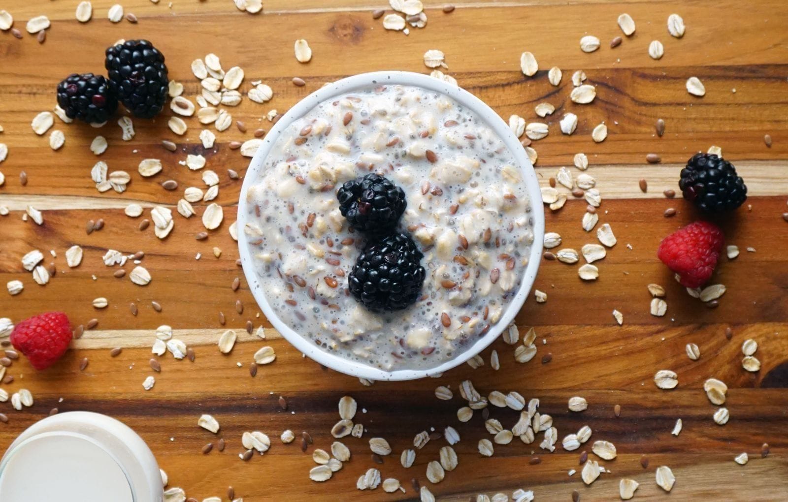 A bowl of oatmeal topped with fresh berries on a wooden table, a high-fiber breakfast