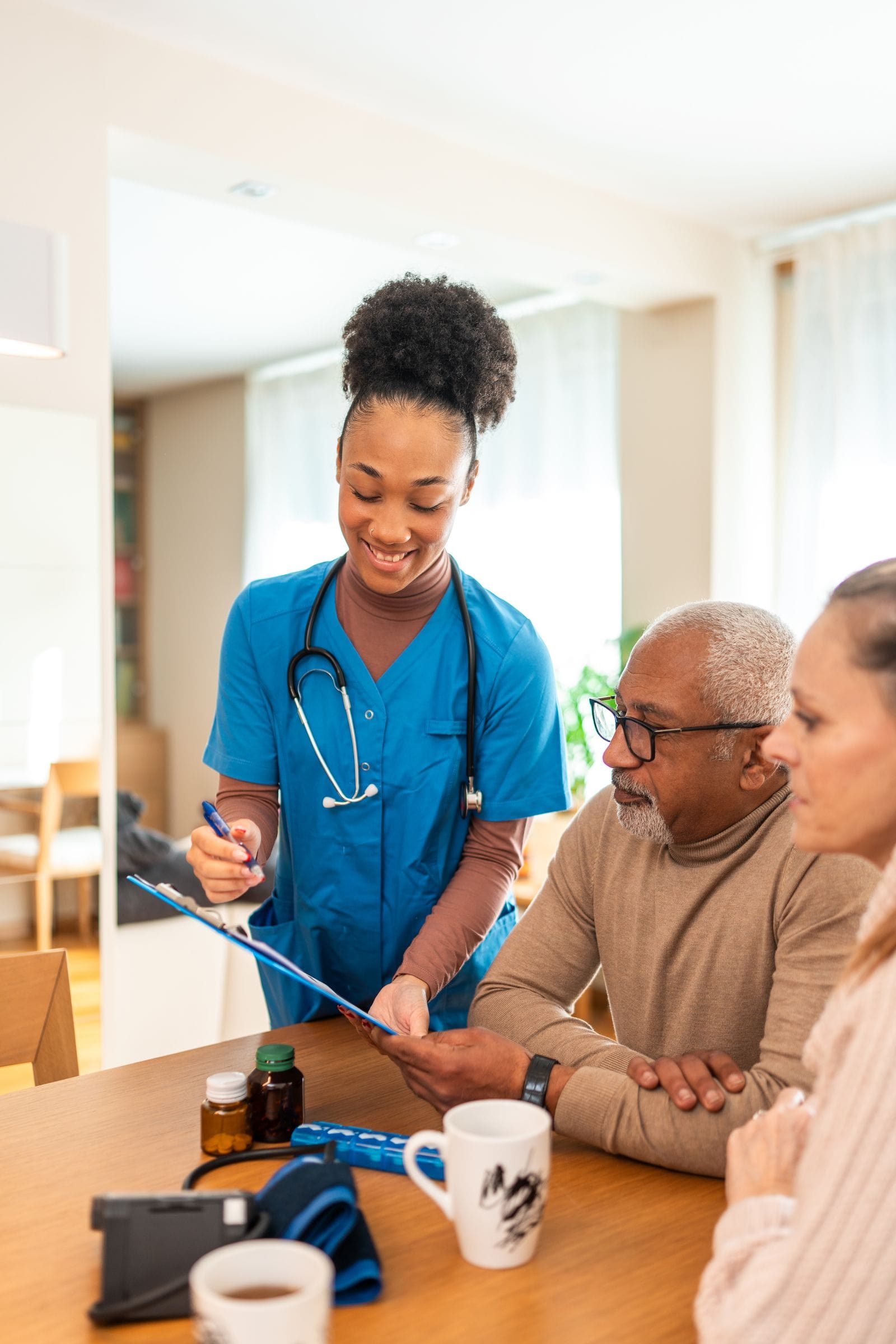 A nurse going over a care plan with an older man and his family at their dining table